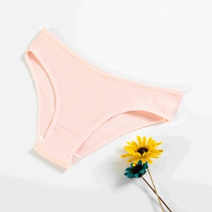 Detailed flat lay of pink ribbed cotton panty on cream background with decorative flowers