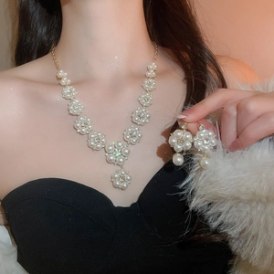 Elegant model wearing flower pearl necklace and tassel earrings with sparkling rhinestones