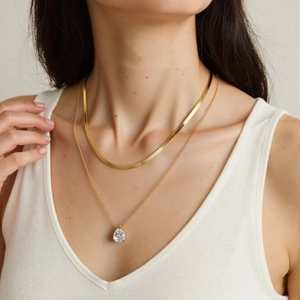 Gold layered stainless steel necklace with pear-cut zircon pendant on fashion model