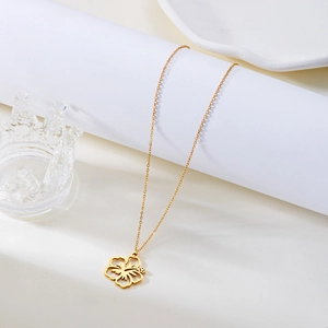 Detailed view of a gold hibiscus hollow flower pendant on a minimalist thin chain