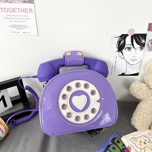 Detail of vintage rotary dial handbag in purple featuring a heart and spiral handle