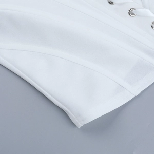 Detailed close-up of white corset top featuring metal eyelets and satin ribbon lace-up detail