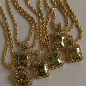 Detail view of gold-plated rope chains with square yellow zircon pendants and micro-pave crystals