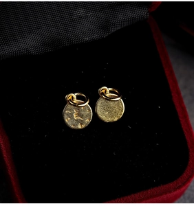 Detailed close-up of gold plated S925 silver Tibetan amulets on black velvet background