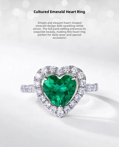 Macro view of heart-shaped emerald green gemstone ring with halo diamond setting
