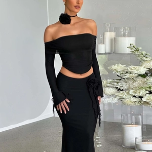 Elegant two-piece black knit set with off-shoulder floral top and slim maxi skirt