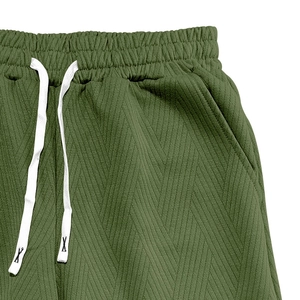 Détail du tissu en maille chevron vert armée et taille élastique avec cordon blanc