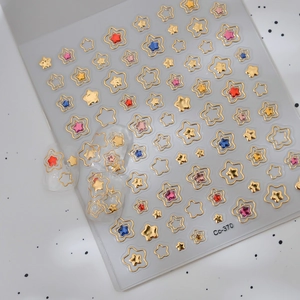 Macro detail of metallic gold star nail stickers with hollow and solid 3D colorful accents