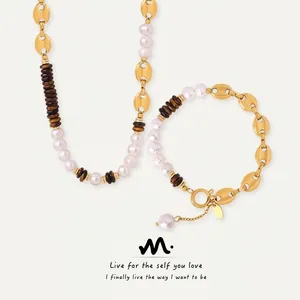 Detail view of gold coffee bean link necklace and bracelet set with pearls and striped beads
