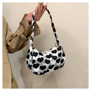 Détail du sac à main imprimé cœurs noir et gris avec fermeture éclair dorée chic