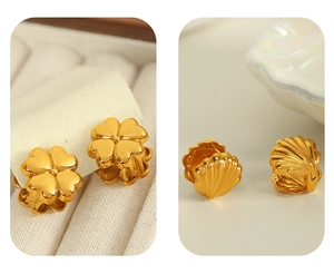Détail de boucles d'oreilles trèfle et coquillage en titane doré sur support velours