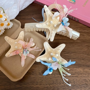 Detail of starfish hair clip with fabric flowers and pearls for beach vacation style