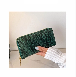 Close-up of dark green embossed PU leather long wallet with golden zipper detail