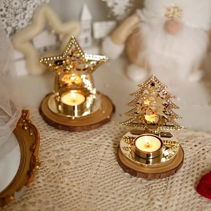 Golden cutout iron Christmas candle holders with star and tree shapes on wood base