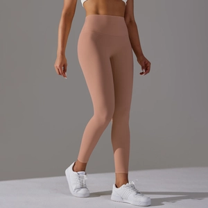 Detail of high waisted peach yoga leggings with smooth elastic fabric and athletic fit