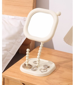 Elegant detail of a cream pearl tabletop makeup mirror with a jewelry storage base