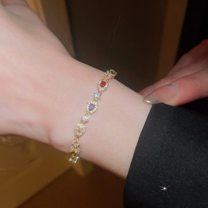 Close-up of elegant gold bracelet with colorful pear-cut gemstones and sparkling zircons