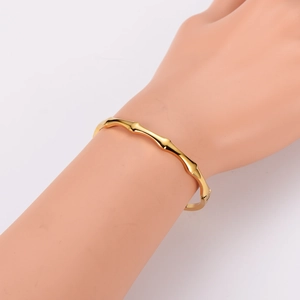 Polished gold wave texture stainless steel bangle with elegant bamboo-inspired design
