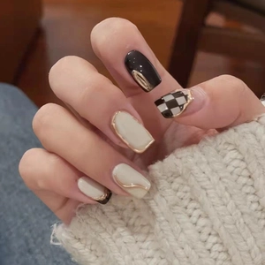 Unghie finte a scacchi stile francese con dettagli neri, beige e bordi oro