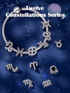 Detailed shot of zodiac charms on a snake chain bracelet with sparkling white zircons