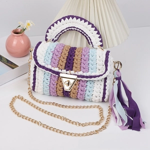 Close-up of handmade crochet crossbody bag with colorful stripes and gold chain strap