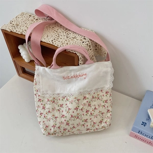 Detalle de bolso de lona con flores, encaje blanco y correa rosa de estilo rústico