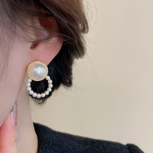 Detailed close-up of French vintage gold pearl earrings on model with elegant texture