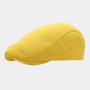 Close-up of bright yellow knitted cotton beret showing fine mesh texture and quality stitching