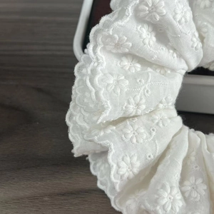 Close-up of white floral embroidery and four-layer lace texture on this hair scrunchie