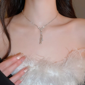 Elegant Y-shaped gold necklace with sparkling crystals on a model neck close-up