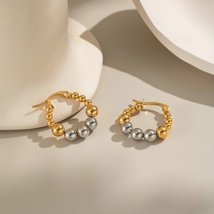 Artistic detail of beaded hoop earrings with gradient gold and silver polished finish