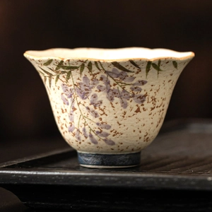 Hand-painted wisteria ceramic teacup with petal-shaped rim and blue ring base
