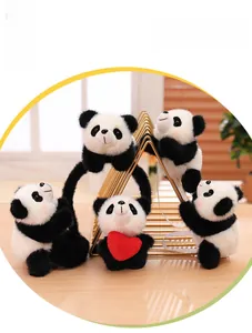 Close-up of plush panda charms with red heart element on golden metal stand