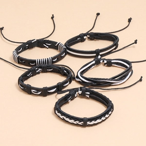 Detailed view of 5-piece set of black and white woven leather bracelets with adjustable ropes
