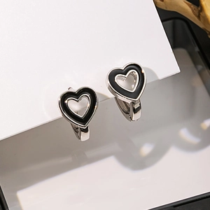 Vue détaillée des boucles d'oreilles cœur géométriques en émail noir et argenté