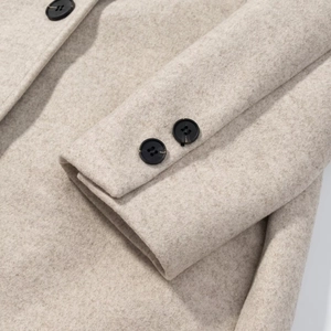 Women's long beige wool coat with single-breasted design and detailed buttoned cuffs