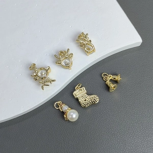 Gold Christmas DIY pendants with reindeer and bells on a textured stone background