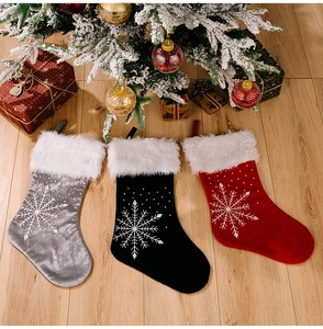Vue détaillée de chaussettes de Noël en velours argent, noir et rouge avec broderies flocons