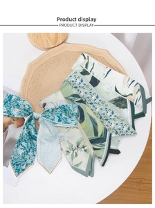 Detail of floral silk hair ribbons and skinny scarves on a round wooden display tray