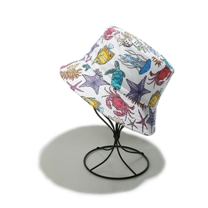 Close-up of a white bucket hat with colorful marine life prints on a metal stand