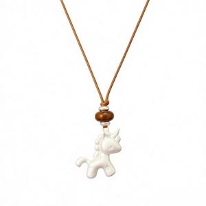 Collier licorne minimaliste en résine blanche avec cordon tressé marron sur fond blanc