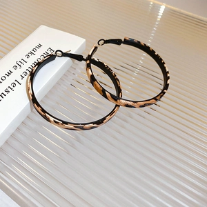 Macro view of hoop earrings featuring classic leopard print on rippled acrylic background