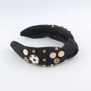 Détail du serre-tête noir en tissu avec breloques de football et strass scintillants