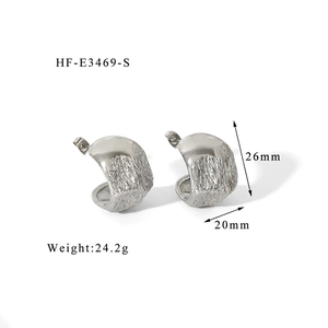 Vue détaillée de boucles d'oreilles créoles argentées avec texture lave irrégulière