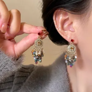 Close-up of vintage flower patterned shell tassel earrings with colorful beads