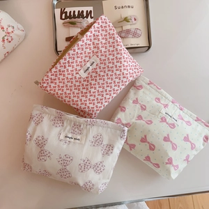Set of three cotton cosmetic bags with sweet bow patterns and secure zipper closure