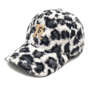 Detail of embroidered gold letter R on leopard print faux teddy fur baseball cap