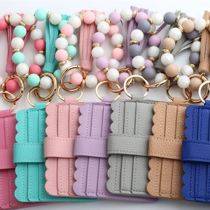 Flat lay of colorful silicone bead bracelet card holders with PU leather wave-edge wallets