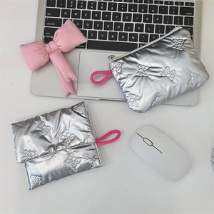 Quilted silver heart cosmetic pouch and card holder on desk with laptop and bow