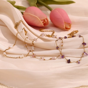 Macro detail of an 18K gold plated stainless steel anklet with natural pearls and stones